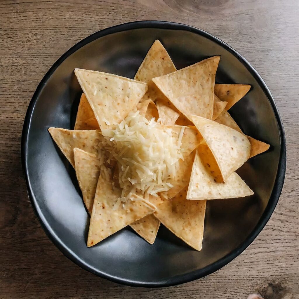 Stap 2. Voeg geraspte kaas en gesnipperde ui toe op nacho chips