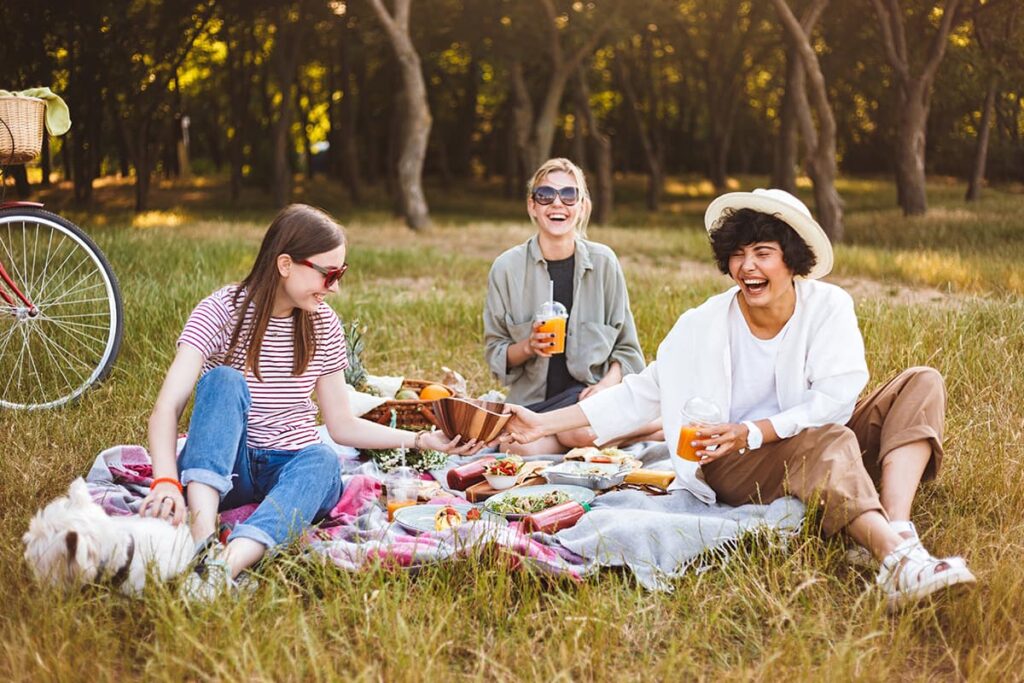 Picknicken met vrienden in de natuur en een rijkgevulde picknickmand