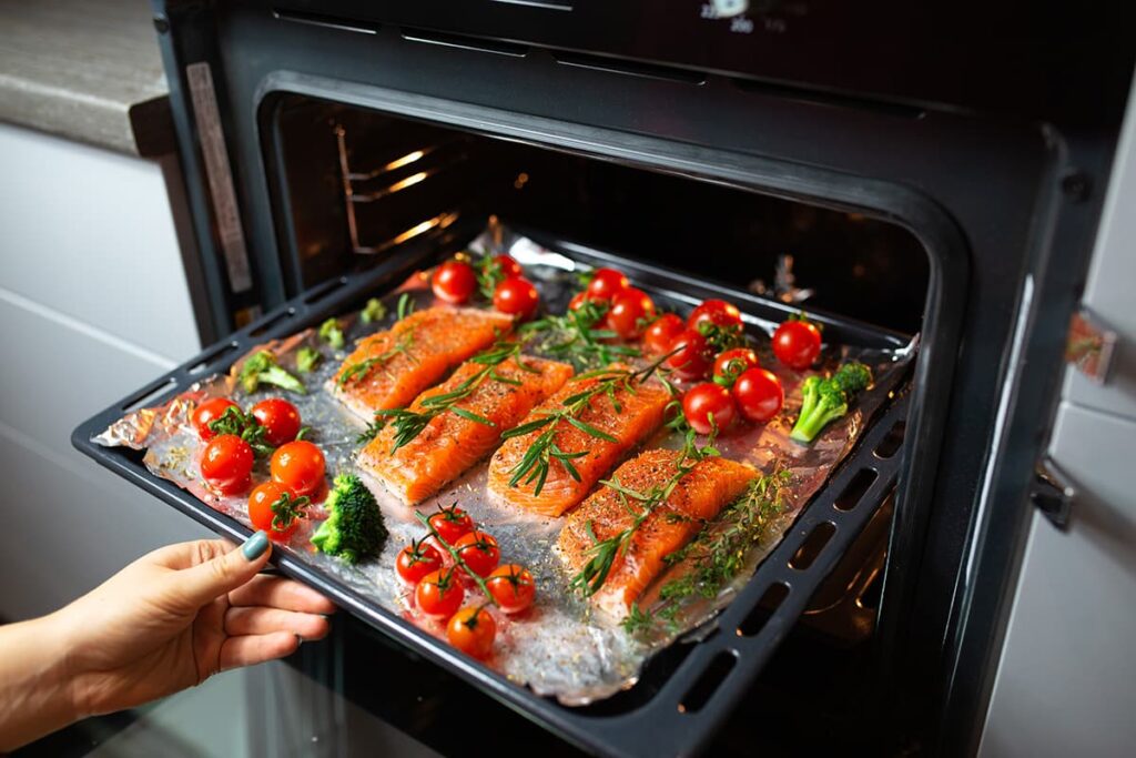 Zalm met groenten uit de oven op een bakplaat