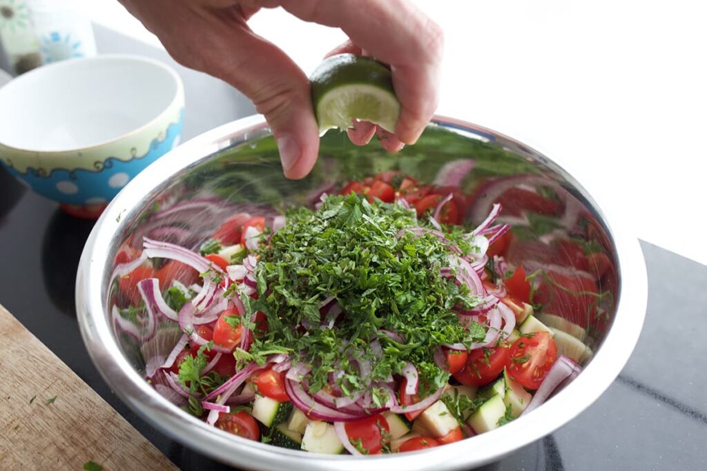 Knijp de halve limoen uit voor de dressing van de pastasalade