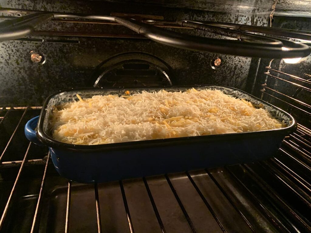 Vegetarische ovenschotel zoete aardappel en gekarameliseerde ui bakken op 180 graden
