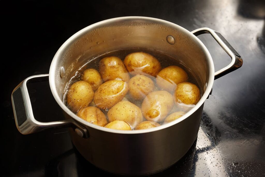 Aardappelen met schil koken in een pan met water