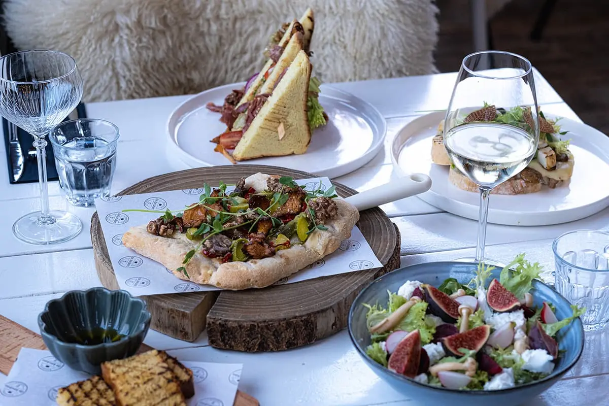 Mooi gedekte tafel met prachtige gerechten bij Brasserie de Keuken Schagerbrug aan de Grote Sloot met historisch torentje en terras aan het water
