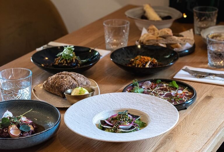 Een tafel vol met verschillende koude en warme gerechten bij Restaurant Krelis 768x523