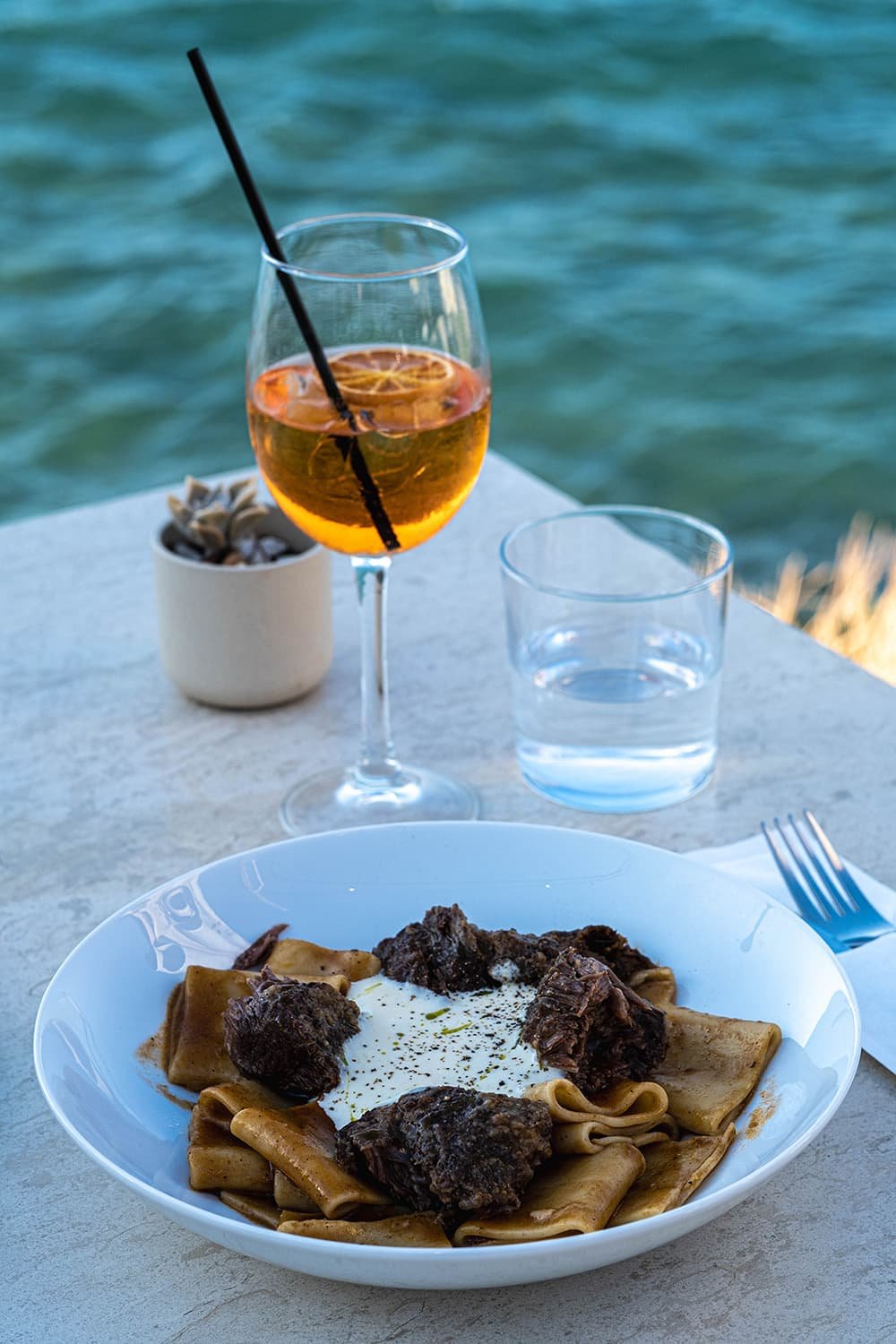 Diner met pasta en een cocktail