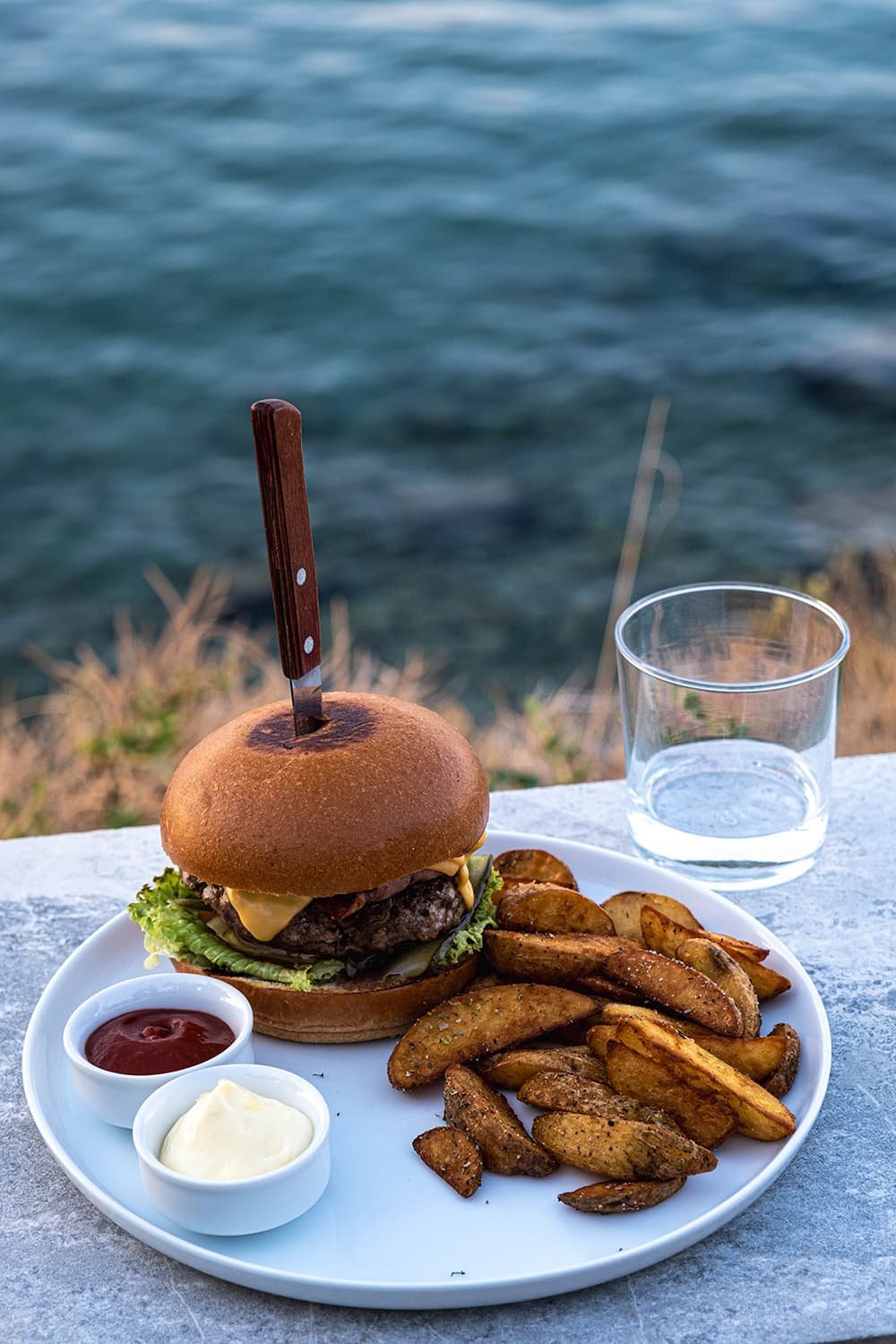 Een grote hamburger en aardappel wedges